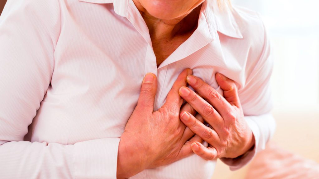 Old woman holding breast because of heart infarction ; Shutterstock ID